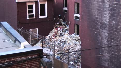 In-This-Innerscene-The-Camera-Pans-Up-And-Over-A-Rooftop-To-View-Trash-Piling-Up-Around-An-Old-Apartment-Building