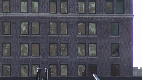 Die-Kamera-Zoomt-Auf-Ein-Unscheinbares-Graues-Gebäude-Mit-Bogenfenstern-Und-Dann-Auf-Ein-Altes-Schulgebäude