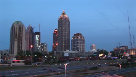 Skyscrapers-Make-Up-The-Background-For-A-Twilight-Panning-Shot-Of-Traffic-Flowing-Along-On-An-Atlanta-Freeway