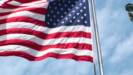 Die-Kamera-Schwenkt-Nach-Rechts-über-Eine-Sich-Kräuselnde-Amerikanische-Flagge-Und-Zeigt-Die-Freiheitsstatue-Im-Hintergrund