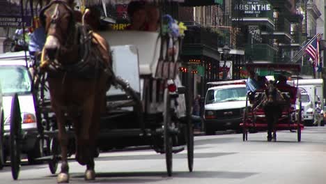 Mule-Buggies-Follow-Each-Other-Down-A-Crowded-Street-In-New-Orleans