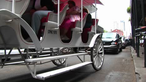 A-Horsedrawn-Tourist-Carriage-Makes-Its-Way-Down-A-Crowded-Street-In-New-Orleans
