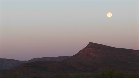 Longshot-Of-The-Moon-Over-A-Rocky-Landscape-1