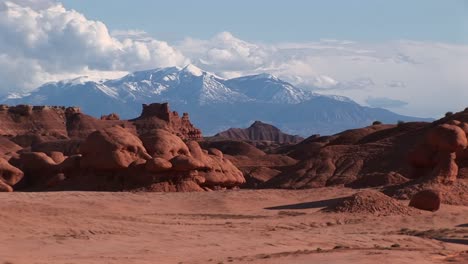Longshot-Of-Sandstone-Formations-And-Snowcovered-Mountains-At-Goblin-Valley-State-Park-In-Utah