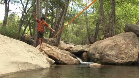 Mediumshot-De-Un-Joven-Slacklining-A-Través-De-Un-Agujero-Para-Nadar