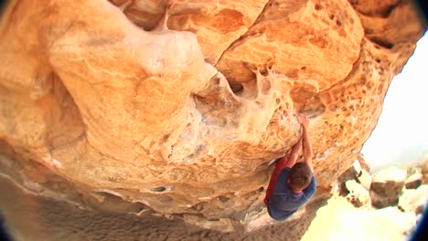 Fisheye-Of-A-Boulderer-Feeling-His-Way-Along-A-Cliff-Face