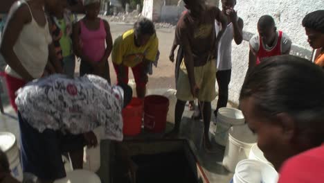 Menschen-Holen-Sich-Wasser-Aus-Einem-Brunnen-Nach-Einem-Schweren-Erdbeben-In-Haiti