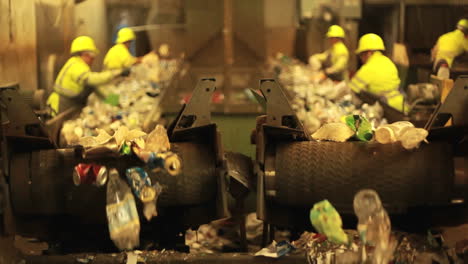 Excellent-shot-of-workers-in-a-recycling-center-sorting-trash-on-conveyor-belts