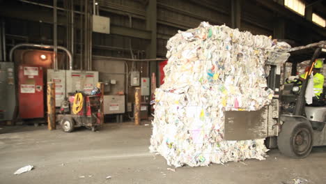 Step-motion-of-a-skip-loader-moves-aluminum-cans-at-a-recycling-center