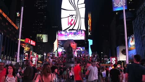 Tilt-Down-Shot-De-Times-Square-Iluminado-Y-Lleno-De-Gente-Por-La-Noche-1