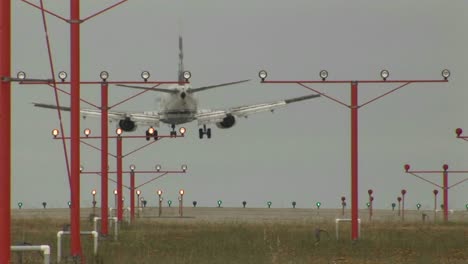 An-airplane-landing-on-a-runway-through-lights-and-guidance-equipment-beams