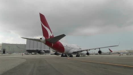 Ein-Qantas-747-Jet-flugzeug-Wird-Auf-Der-Rampe-Eines-Flughafens-Gezogen