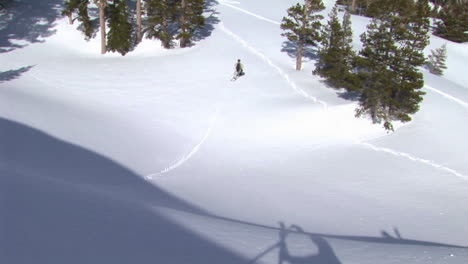 Following-shot-of-a-snowboarder-as-he-makes-a-thrilling-jump-from-a-cliff-and-makes-a-good-landing