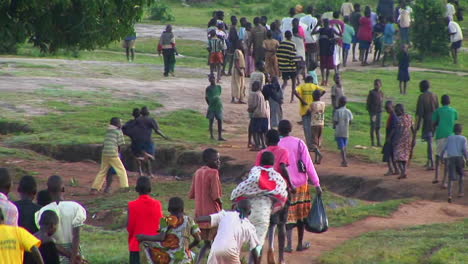 Longshot-of-African-niños-run-down-a-country-road