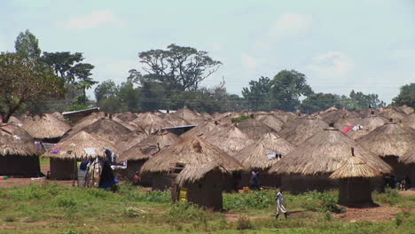 Disparo-De-Una-Niña-Caminando-Hacia-Una-Pequeña-Aldea-O-Campamento-De-Refugiados-En-Uganda,-África