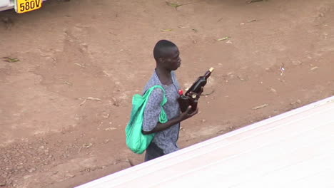 A-man-carries-beer-bottles-through-traffic-in-Kampala-Uganda