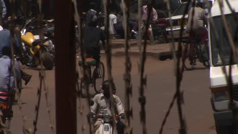 Bicycles-and-motorcycles-drive-behind-a-barbed-wire-fence-in-Uganda