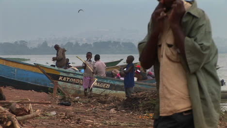 Jungen-Stehen-Vor-Fischerbooten-Im-Dorf-Gaba-Am-Ufer-Des-Lake-Victoria-Uganda