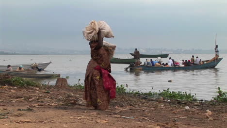 Panright-of-a-heavily-laden-woman-carrying-parcels-to-a-fishing-boat--on-the-shores-of-Lake-Victoria