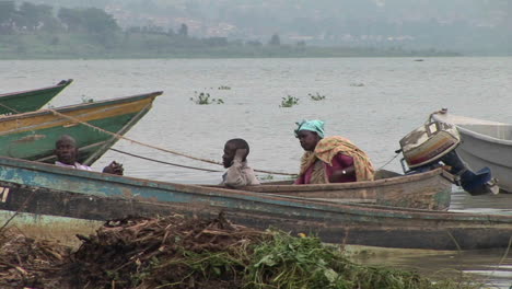 Mittlerer-Schuss-Afrikanischer-Fischer,-Die-In-Einem-Boot-Am-Ufer-Des-Victoria-Uganda-Sees-Ruhen