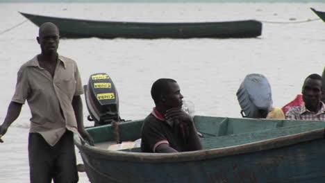 Mediumshot-of-fishermen-and-their-boats-along-the-shore-of-Lake-Victoria-Uganda