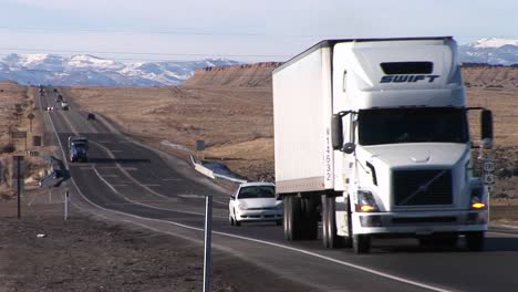 A-semi-truck-moves-along-a-highway-through-the-Rocky-Mountains