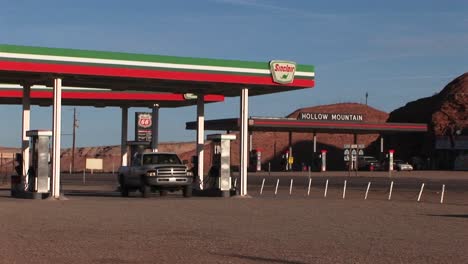 Medium-shot-of-a-pickup-truck-leaving-a-desert-gas-station