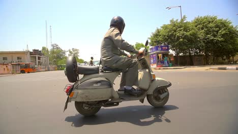 Dos-hombres-montan-sus-ciclomotores-en-la-India