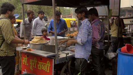 Toma-de-mano-del-vendedor-indio-de-comida-callejera