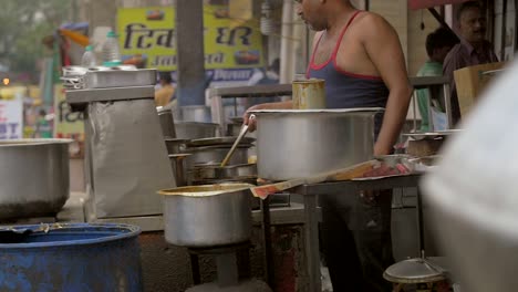 Hombre-agrega-especias-a-la-comida-en-un-puesto