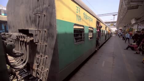 Pasajeros-que-abordan-un-tren-indio-en-movimiento