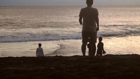Gruppe-Von-Menschen-Silhouette-Am-Strand-Bei-Sonnenuntergang