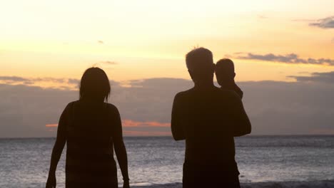 Silhouette-Einer-Familie,-Die-Bei-Sonnenuntergang-Am-Strand-Entlang-Geht