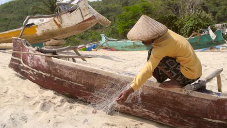 Pescador-desenredando-redes-en-una-playa