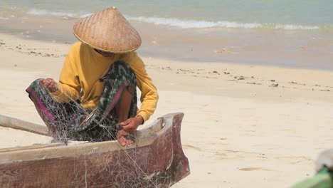 Indonesischer-Fischer-Entwirrt-Netze-Auf-Einem-Kanu