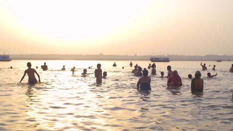 Toma-panorámica-de-bañistas-en-el-Ganges-al-atardecer