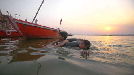 Junge-Und-Mädchen-Schwimmen-In-Den-Ganges-Bei-Sonnenuntergang
