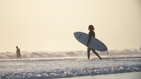 Hombre-caminando-hacia-el-mar-con-una-tabla-de-surf