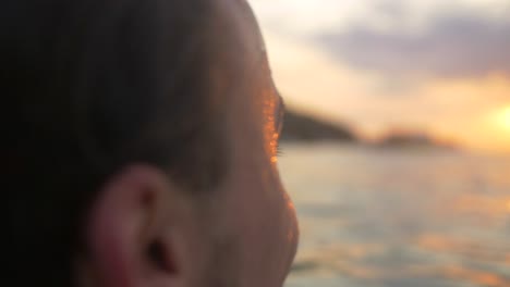 Hombre-sonriendo-en-el-mar-al-atardecer