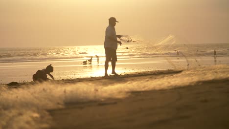 Mann-Faltet-Fischernetz-Bei-Sonnenuntergang