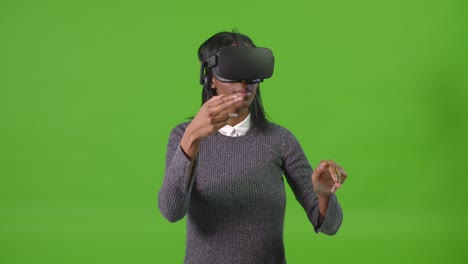 Junge-Frau-Auf-Grünem-Bildschirm,-Die-Mit-VR-Headset-Gestikuliert