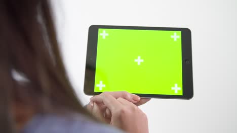 Mujer-joven-gesticulando-en-tableta-de-pantalla-verde