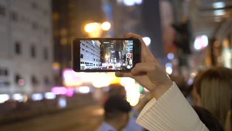 Person-Filming-Parade-on-Smartphone