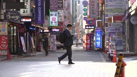 Businessman-Walking-Past-Neon-Signs