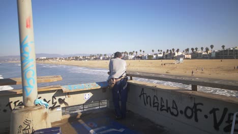Hombre-mirando-a-Venice-Beach-desde-el-muelle