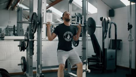 Hombre-en-cuclillas-con-pesas-en-el-gimnasio