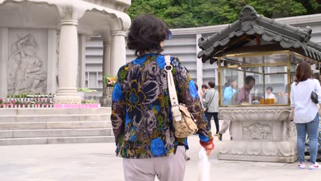 Woman-Walking-Through-Buddhist-Temple