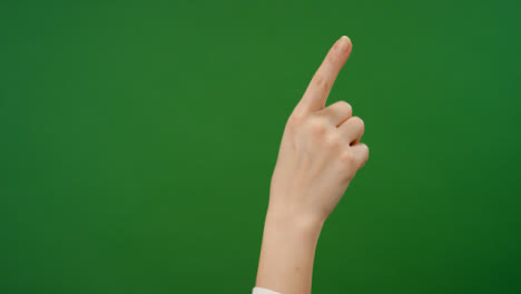 Dedo-femenino-haciendo-gestos-de-deslizamiento-en-pantalla-verde