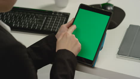 Mujer-de-CU-haciendo-gestos-de-deslizamiento-en-tableta-con-pantalla-verde