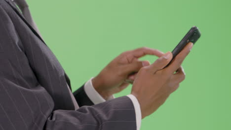 CU-businessman-typing-on-phone-with-green-screen